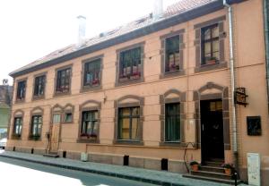 Un gran edificio con ventanas y puertas que da a una calle. en Residence Castelului, en Brasov