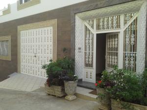 una puerta delantera de una casa con macetas en Fnideq Seaside Apartment, en Fnidek