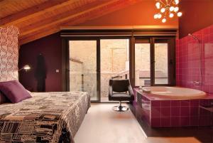 a bedroom with a tub and a bed and a chair at Casa Rural Luces y Sombras in Prádena