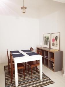 ein Esszimmer mit einem weißen Tisch und Stühlen in der Unterkunft Casa da Madrinha I in Monte Gordo