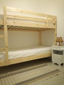 ein Etagenbett aus Holz in einem Zimmer in der Unterkunft Casa da Madrinha I in Monte Gordo