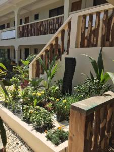 a garden in front of a house with a staircase at Stardust Beach Hotel in Lian