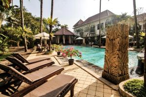 einen Pool mit Chaiselongues neben einem Resort in der Unterkunft Sarasvati Borobudur in Borobudur