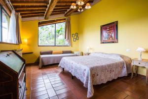 a bedroom with two beds and a couch and a tv at Agriturismo La Villa Romita in Tavarnelle in Val di Pesa
