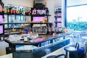 a bar in a restaurant with a counter and stools at Hotel Barbiani in Rimini