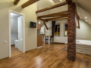 a living room with a brick pillar and a bedroom at Studio Unseen Brasov in Braşov