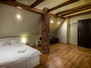 a bedroom with a white bed and a brick pillar at Studio Unseen Brasov in Braşov