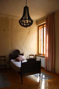 a bedroom with a bed and a chandelier at Lindstedter Gutsstuben in Gardelegen