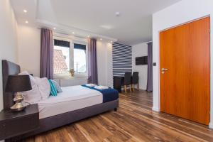 a bedroom with a bed and a wooden floor at MiraMar-Adults only-Grupa PlażoweLove in Krynica Morska
