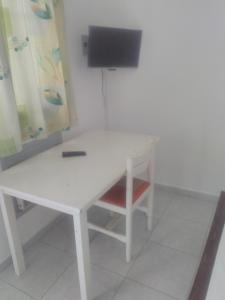 a white table with a chair and a television at Residence Belle Vue Palmeraie in Abidjan