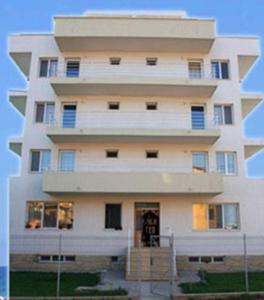 ein hohes weißes Gebäude mit der Vorderseite in der Unterkunft Villa Teo in Costinești