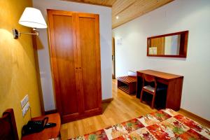 a room with a bed, a desk and a lamp at Hotel Montseny in Espúy