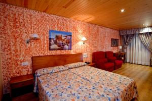 a bedroom with a bed and a red chair at Hotel Montseny in Espúy