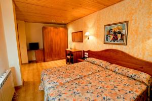 a hotel room with a bed and a television at Hotel Montseny in Espúy