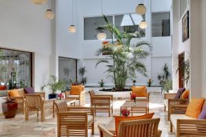 a lobby with chairs and a table and a plant at Zodiaco in Quarteira