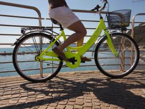 a woman riding a lime green bike on a pier at Hotel Stella Del Mare in Chiavari
