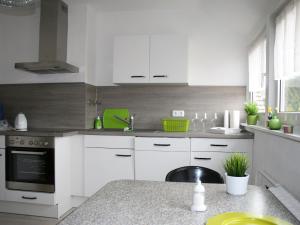 eine Küche mit weißen Schränken und einer Arbeitsplatte in der Unterkunft Ferienwohnung Ruhepol in Vellmar