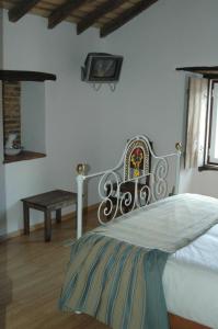 a bedroom with a bed and a bench and a tv at Quinta Do Vaqueirinho - Agro-Turismo in Marvão