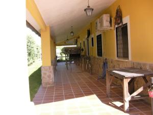 a porch of a house with a table at La Posada Hípica in Rosalejo