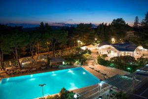 una vista panoramica su una piscina di notte di Hotel Sierra Silvana a Selva di Fasano