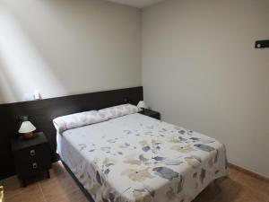 1 dormitorio con 1 cama con edredón de flores en Merola, en LʼAmetlla de Merola