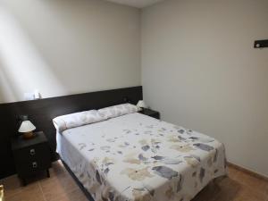 a bedroom with a bed with a floral comforter at Merola in LʼAmetlla de Merola