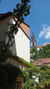 a white building with a church in the background at Hotel Schlossberg in Meißen