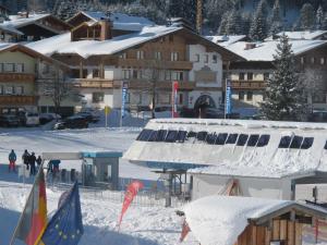 eine Gruppe von Menschen im Schnee vor Gebäuden in der Unterkunft Appartement Schörghofer in Filzmoos