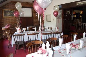 einen Tisch mit rosa und weißen Ballons in einem Zimmer in der Unterkunft Hogs Head Hotel in Nottingham