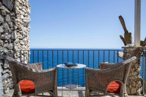 a patio with two chairs and a table and the ocean at Hotel Piccolo Mondo in Castro di Lecce