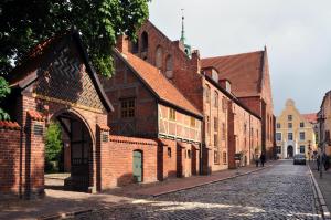 an old brick building on a cobblestone street at Herberge KAFFETIET in Wismar