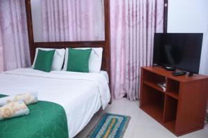 a bedroom with two beds with a tv and a couch at Sevonrich Holiday Resort in Dambulla