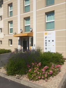 a hotel with flowers in front of a building at Première Classe Epernay in Épernay