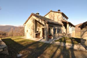 an old stone house on a grassy field at Ospitalita' Rurale Casa Cani in Berceto