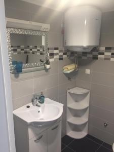 bagno bianco con lavandino e specchio di Apartments Bakula a Mandre