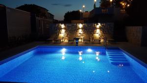 two people in a swimming pool at night at Villa Anka in Rab