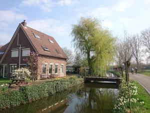 una casa junto a un río con un puente en Guest House Ons Hoekje en Houten