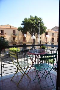 un tavolo e 2 sedie su un balcone con tavolo di The Night Guest House a Sorrento