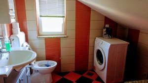 a bathroom with a sink and a washing machine at Apartman Dadić in Malinska