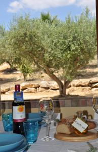 un tavolo con un piatto di cibo e una bottiglia di vino di Casa vacanza Nocellara a Menfi Altre 27 foto
