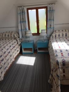 a bedroom with two beds and a window at Le Penty in Landévennec
