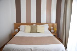 un letto in una stanza con parete a righe di The Night Guest House a Sorrento