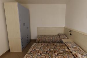 1 Schlafzimmer mit 2 Betten und einem Schrank in der Unterkunft Residence Vecchio Faro in Cavallino-Treporti