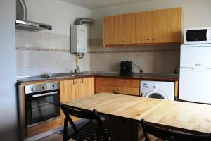 a kitchen with a wooden table and a white appliance at Fontes Viewpoint in Santa Cruz da Graciosa
