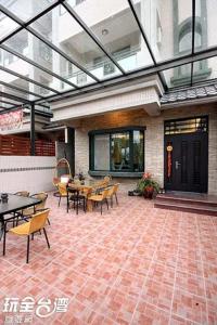 a patio with tables and chairs in a building at 百分百民宿 in Taitung City