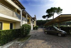 un coche aparcado en un aparcamiento al lado de un edificio en Appartamenti Faro Vecchio en Cavallino-Treporti