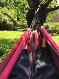 a person laying in a hammock in a park at Gîte La Source in Grusse