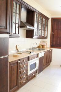 uma cozinha com armários de madeira e um lavatório em Casavillena Apartamentos Turísticos em Segóvia