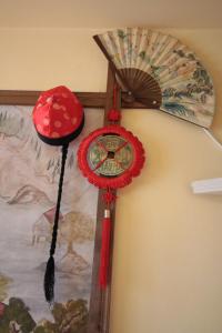 a clock hanging on a wall with a fan at Guest House Unika in Tryavna