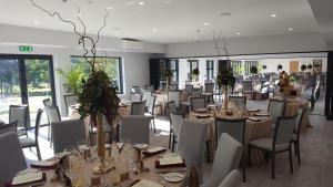 a dining room with tables and chairs and a room with windows at The Brander Lodge Hotel and Bistro in Taynuilt